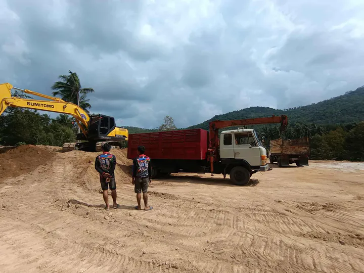 Loading and hauling soil with a dump truck after excavation and grading