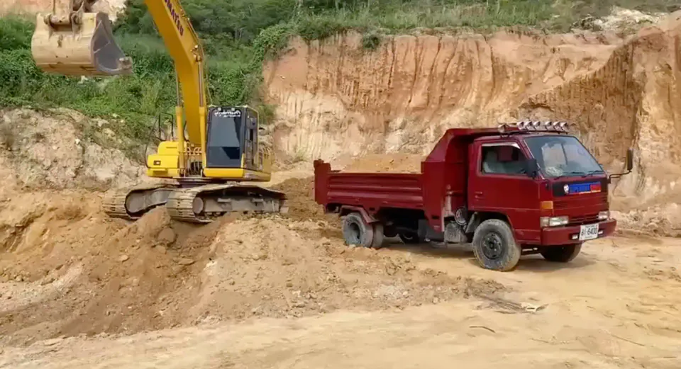 Excavator and dump truck working on the same site
