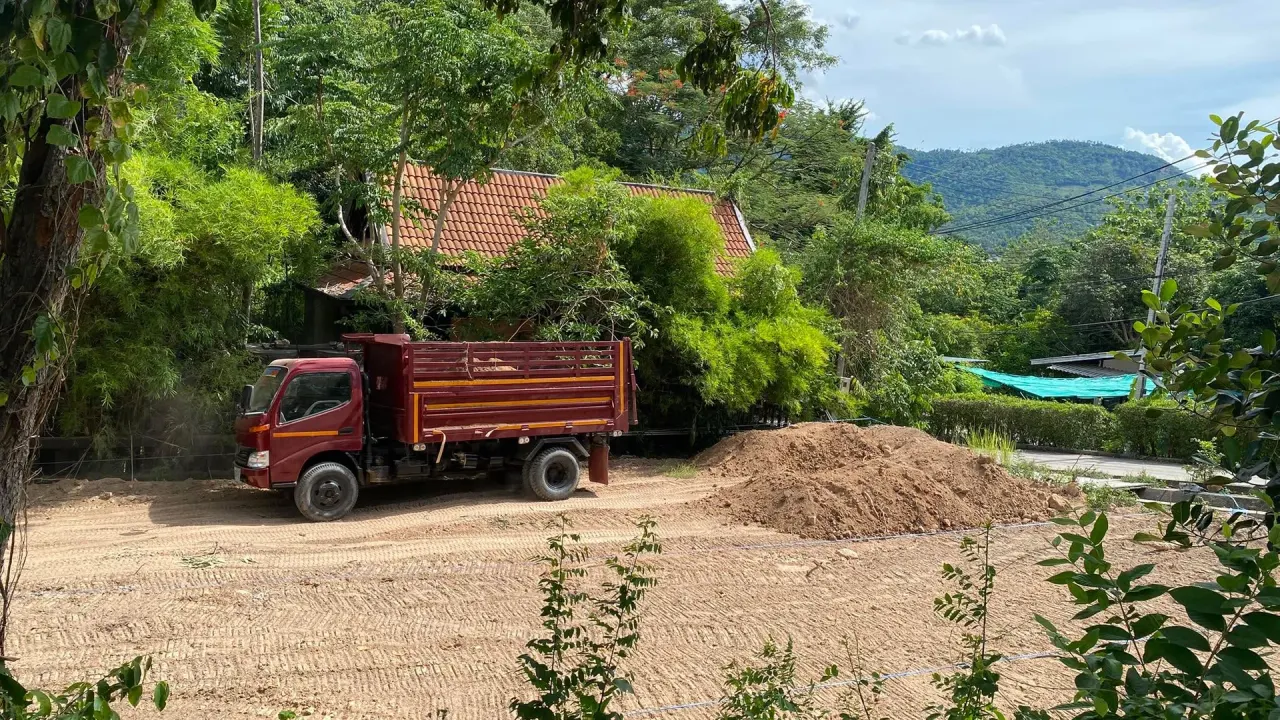 Dump truck unloading soil at the required point on the plot