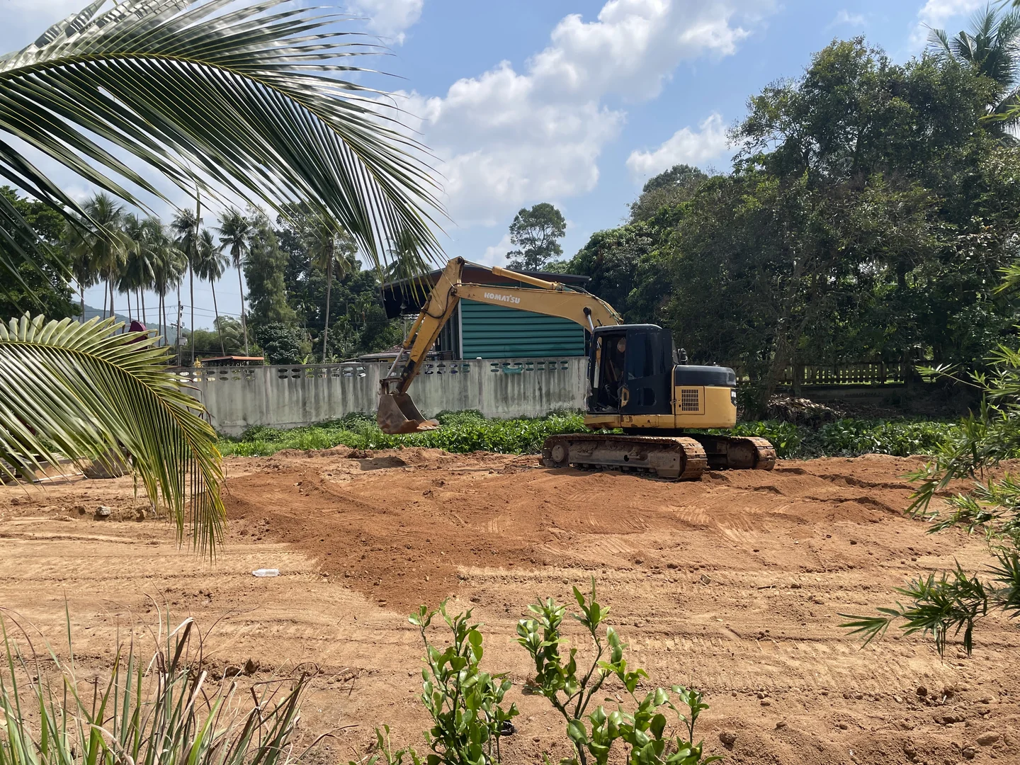 Komatsu PC128 working alongside the tractor to level and compact the fill