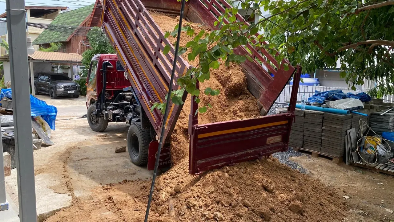 Dump truck unloading the imported fill on the client's property