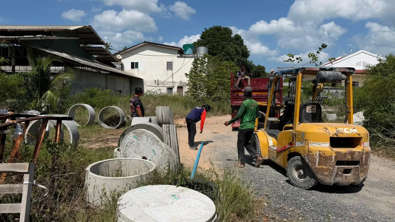 Loading concrete septic rings onto the truck at the supplier's yard