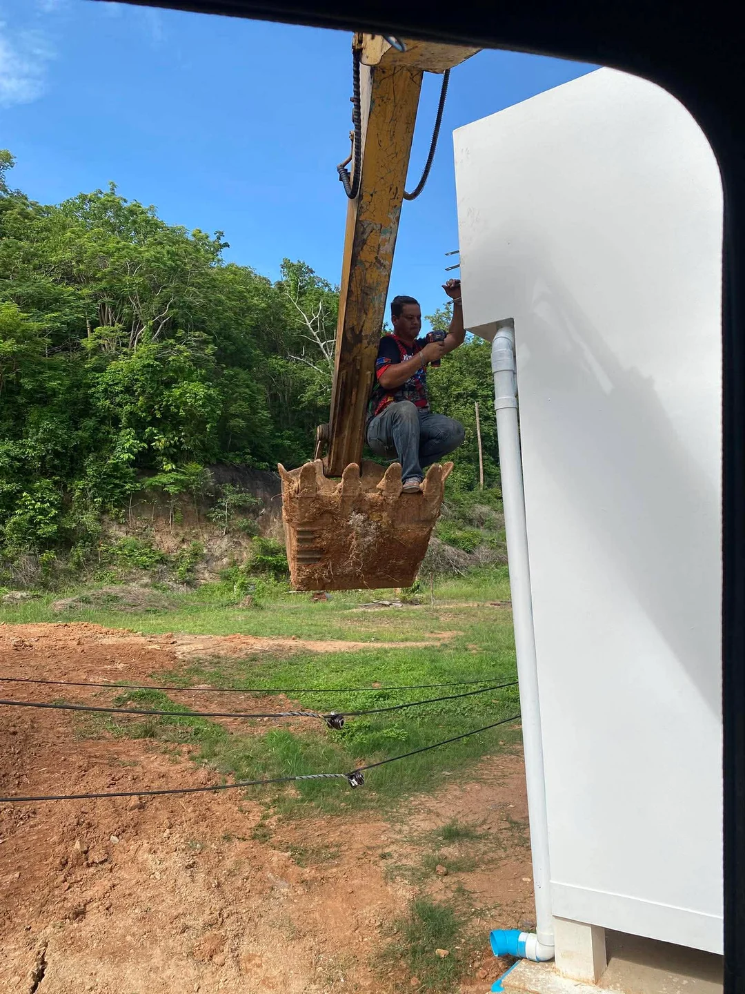Our crew member removing overhead wires to allow truck and excavator access to the site