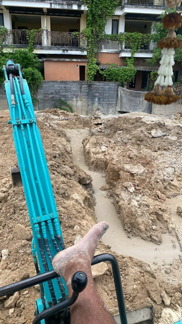 Excavator digging a drainage trench on Koh Samui land