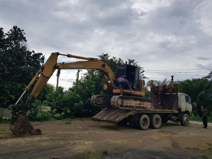 Excavator loading soil into dump truck for transport