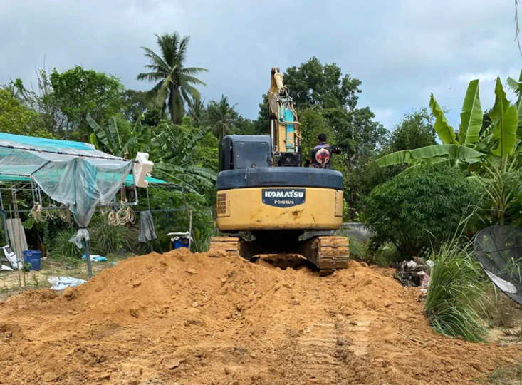 Grading and leveling an access road on a land plot